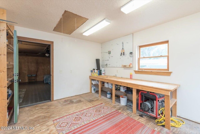 interior space with a workshop area, a textured ceiling, and wood-type flooring