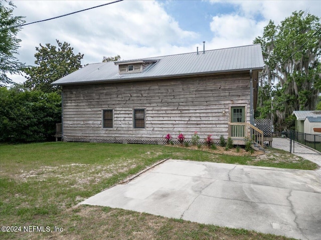 back of property with a patio area and a lawn