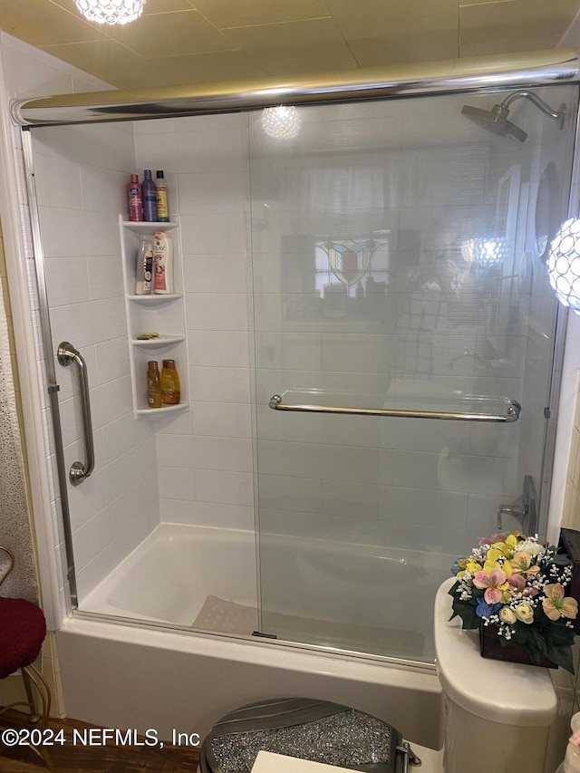 bathroom featuring toilet and enclosed tub / shower combo