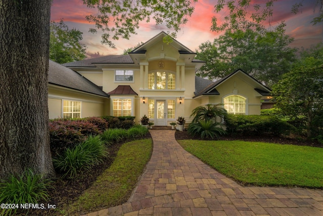 view of front of house featuring a lawn and french doors