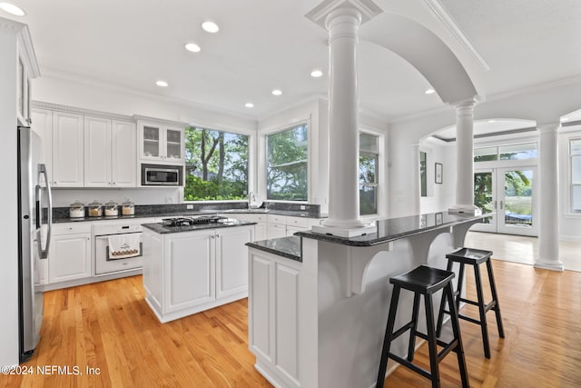 kitchen featuring a center island, white cabinets, and ornate columns