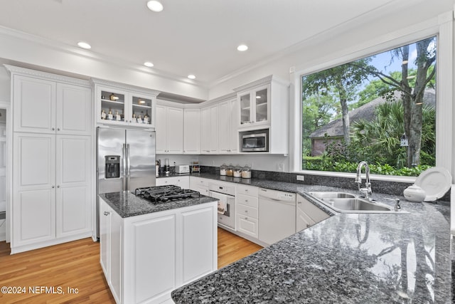 kitchen featuring sink, white cabinets, built in appliances, light hardwood / wood-style floors, and crown molding