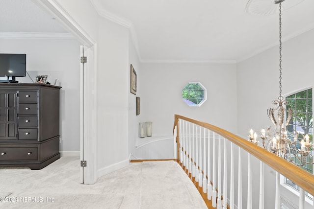 corridor with crown molding, a wealth of natural light, light carpet, and a chandelier