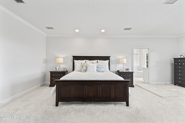 carpeted bedroom featuring ensuite bath and ornamental molding