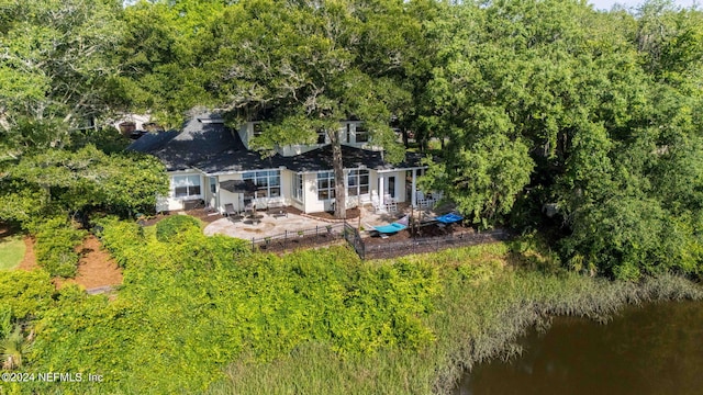 rear view of house featuring a patio area and a water view