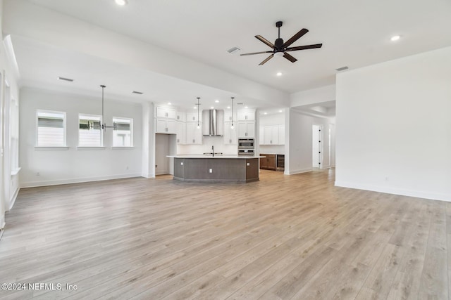 unfurnished living room with ceiling fan and light hardwood / wood-style floors