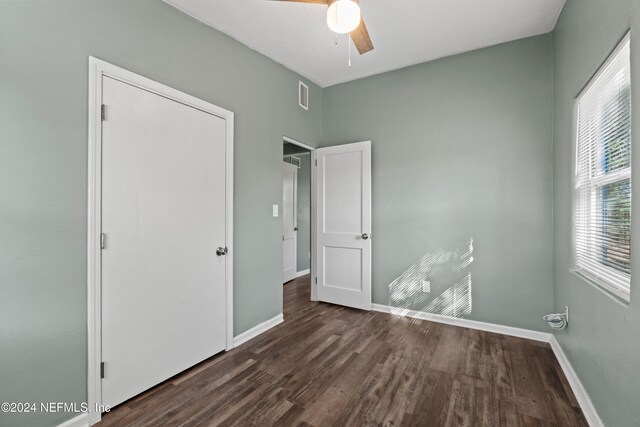 unfurnished bedroom featuring a closet, ceiling fan, and dark hardwood / wood-style flooring