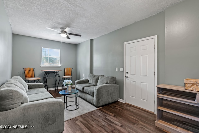 living room featuring a textured ceiling, dark hardwood / wood-style floors, and ceiling fan