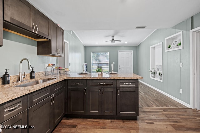 kitchen with dark brown cabinetry, ceiling fan, sink, dark wood-type flooring, and kitchen peninsula