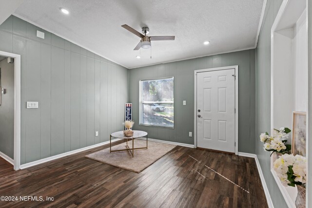 sitting room featuring a textured ceiling, ceiling fan, ornamental molding, and dark wood-type flooring