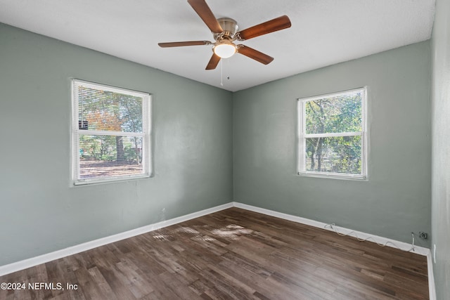 unfurnished room with ceiling fan, a healthy amount of sunlight, and dark hardwood / wood-style flooring