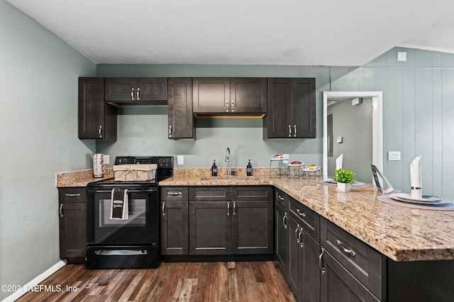 kitchen with dark hardwood / wood-style flooring, light stone counters, black electric range, and sink