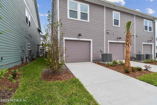 view of front of home featuring a garage and central AC