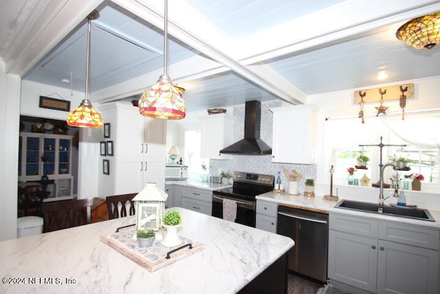 kitchen featuring wall chimney range hood, a wealth of natural light, appliances with stainless steel finishes, sink, and tasteful backsplash