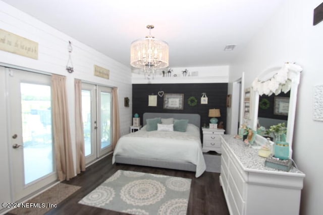 bedroom featuring access to exterior, an inviting chandelier, french doors, and dark wood-type flooring