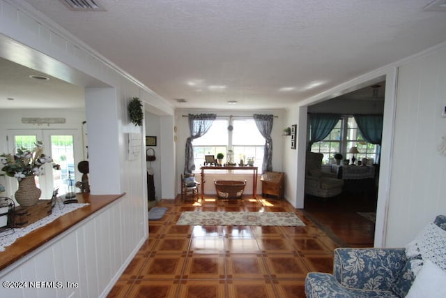 interior space featuring tile floors, french doors, and ornamental molding