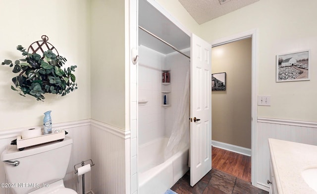 full bathroom featuring a textured ceiling, toilet, shower / bath combo, and vanity