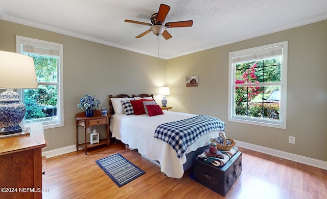 bedroom with ceiling fan, hardwood / wood-style floors, and crown molding