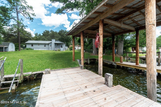 dock area with a water view and a yard