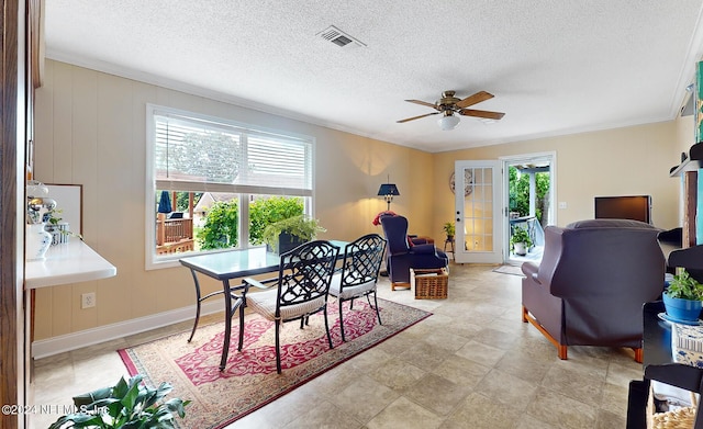 dining room featuring plenty of natural light, ornamental molding, and a textured ceiling