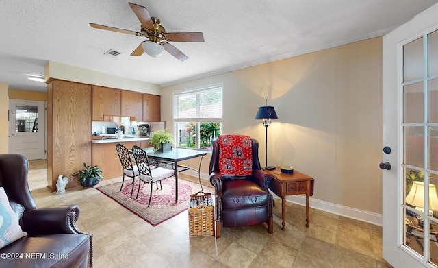 dining room with ceiling fan and a textured ceiling