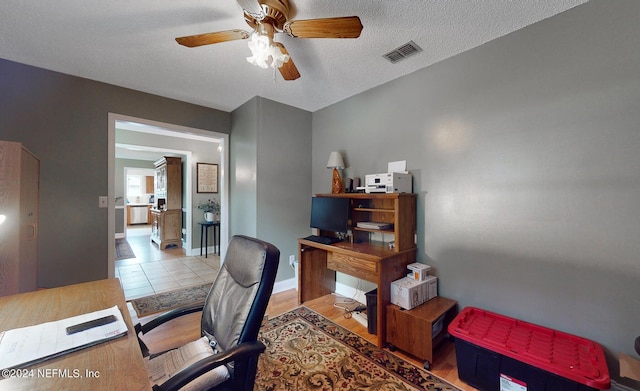 office space with ceiling fan, light wood-type flooring, and a textured ceiling