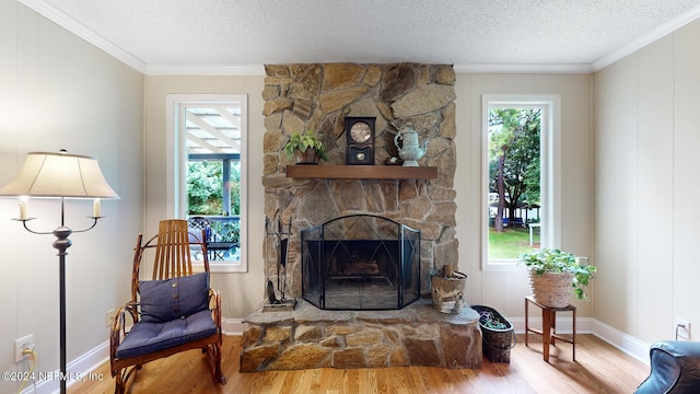 living room with a textured ceiling, a healthy amount of sunlight, a fireplace, and hardwood / wood-style flooring