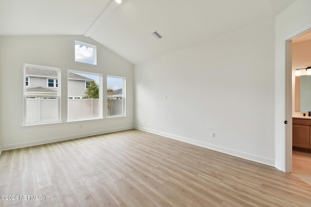 spare room featuring high vaulted ceiling and light hardwood / wood-style flooring