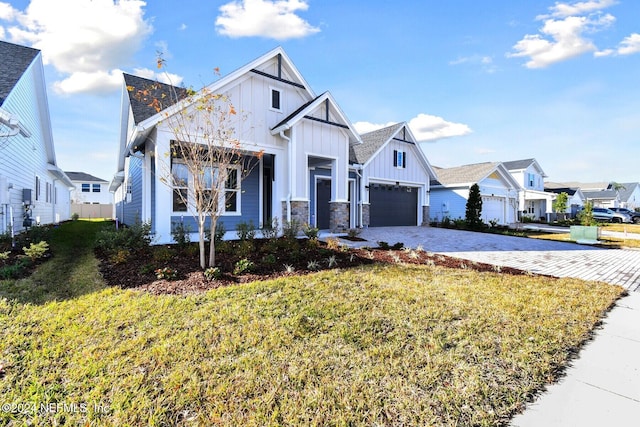 modern farmhouse style home with a front yard and a garage