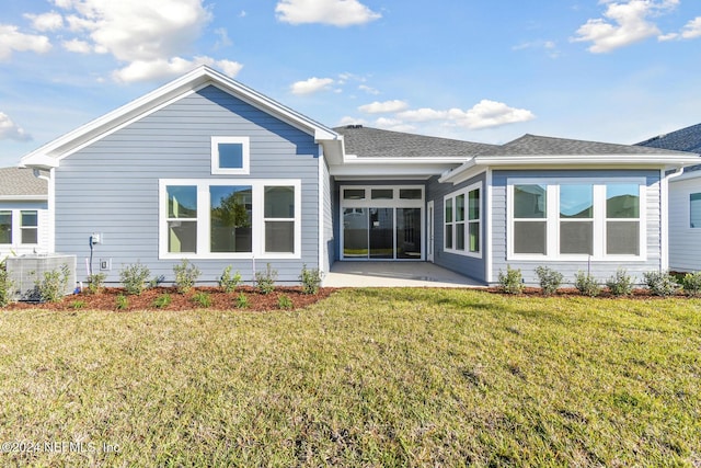 rear view of house with a patio area, central air condition unit, and a yard