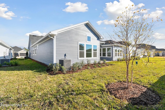 back of property featuring a yard and cooling unit