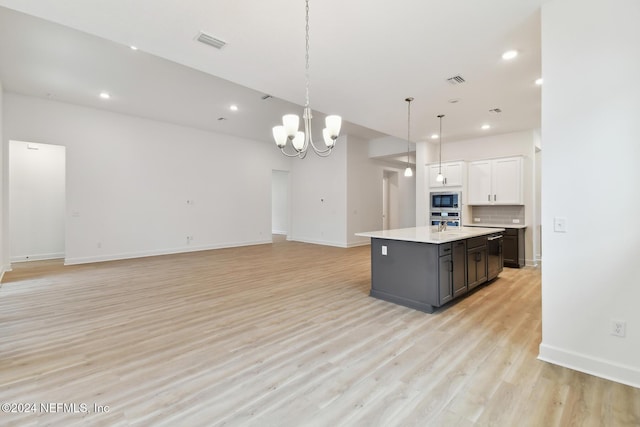 kitchen with white cabinetry, stainless steel appliances, light hardwood / wood-style flooring, pendant lighting, and a kitchen island