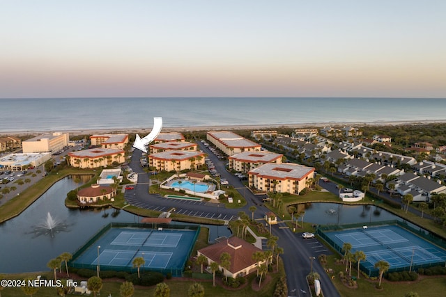 aerial view at dusk featuring a water view