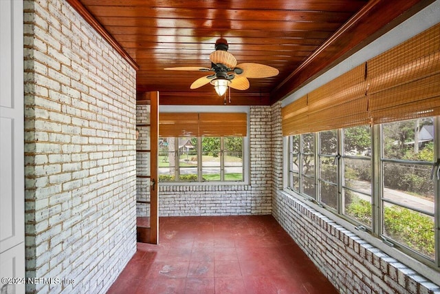 unfurnished sunroom featuring wooden ceiling and ceiling fan