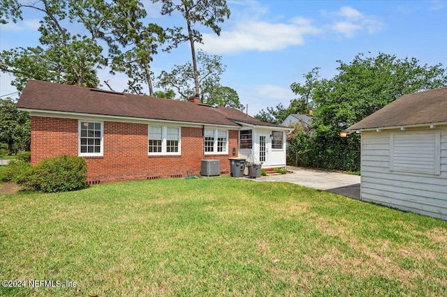 rear view of house with a lawn and central air condition unit