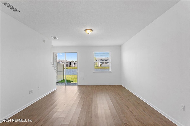 empty room featuring a textured ceiling and hardwood / wood-style flooring