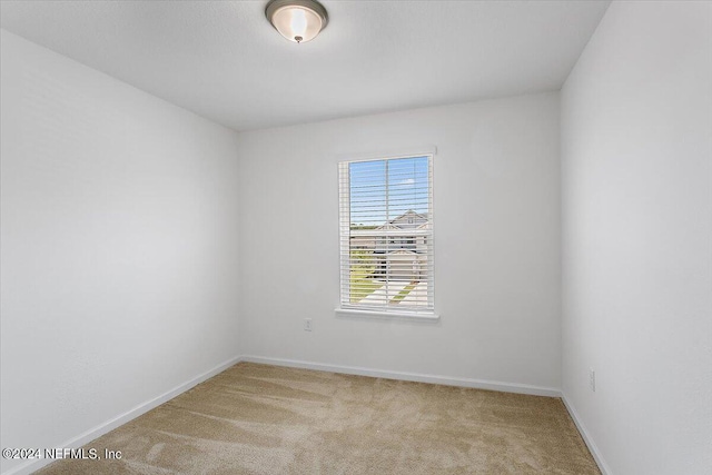 unfurnished room featuring light carpet