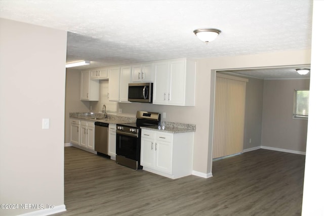 kitchen featuring appliances with stainless steel finishes, white cabinetry, and dark hardwood / wood-style flooring