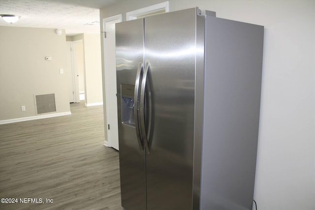 kitchen with stainless steel refrigerator with ice dispenser and hardwood / wood-style floors