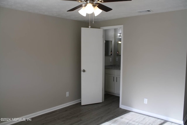 unfurnished bedroom featuring ceiling fan and dark hardwood / wood-style flooring