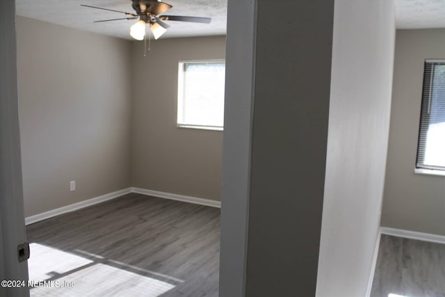 spare room with a healthy amount of sunlight, hardwood / wood-style floors, and ceiling fan