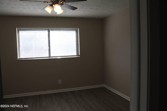 empty room with dark hardwood / wood-style floors, ceiling fan, and a textured ceiling