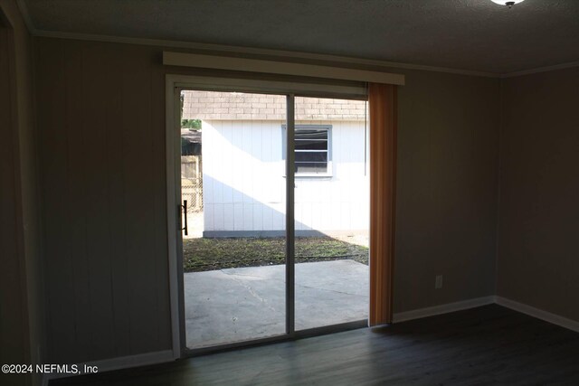 doorway with dark hardwood / wood-style floors and ornamental molding