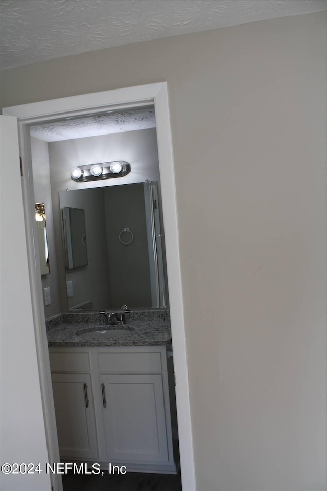 bathroom featuring a textured ceiling and vanity