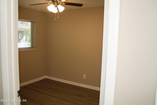 empty room with ceiling fan and dark wood-type flooring