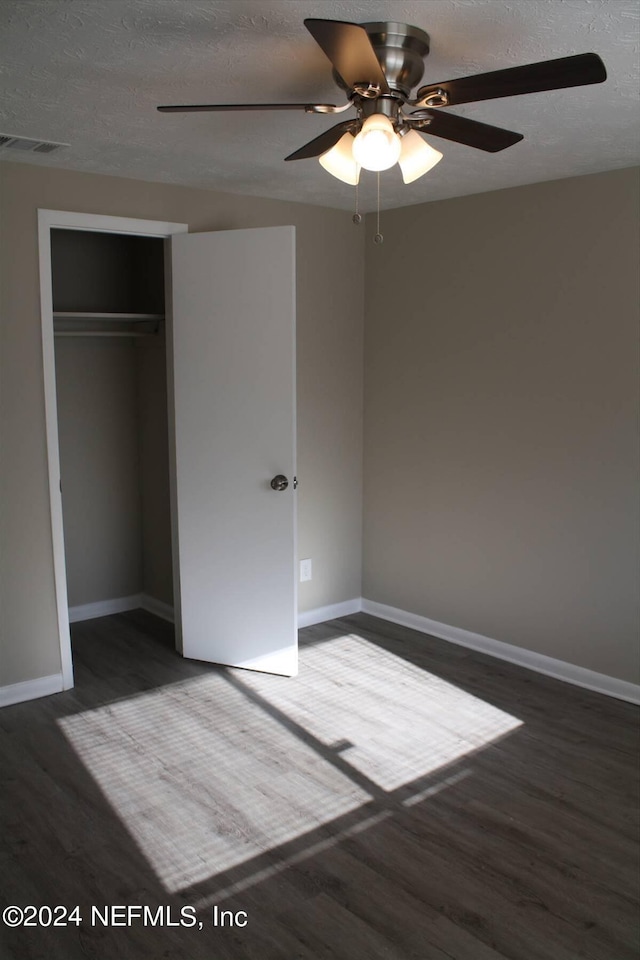 interior space featuring dark hardwood / wood-style flooring, a closet, ceiling fan, and a textured ceiling