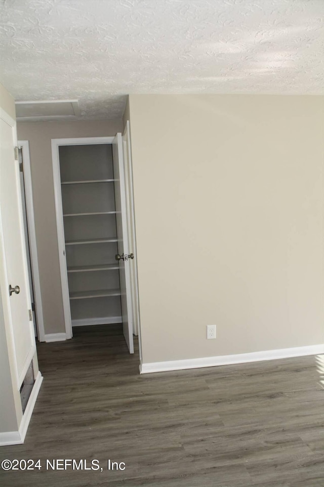 empty room featuring dark hardwood / wood-style flooring and a textured ceiling