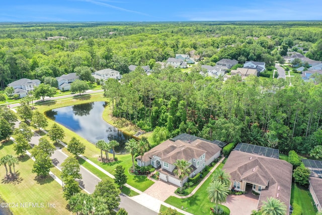 drone / aerial view with a water view and a wooded view