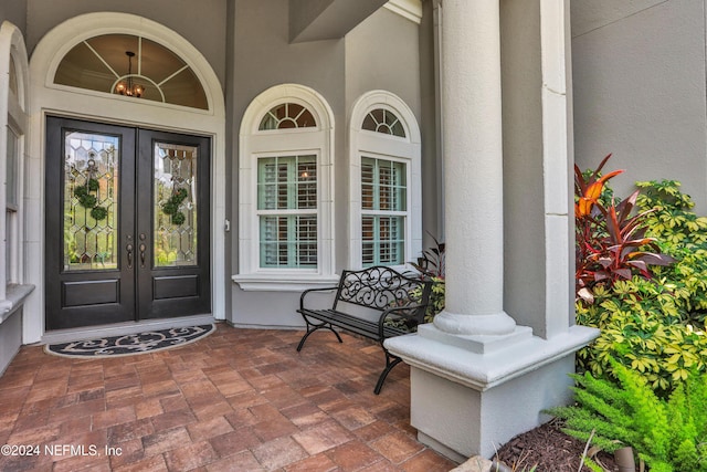 view of exterior entry featuring stucco siding and french doors