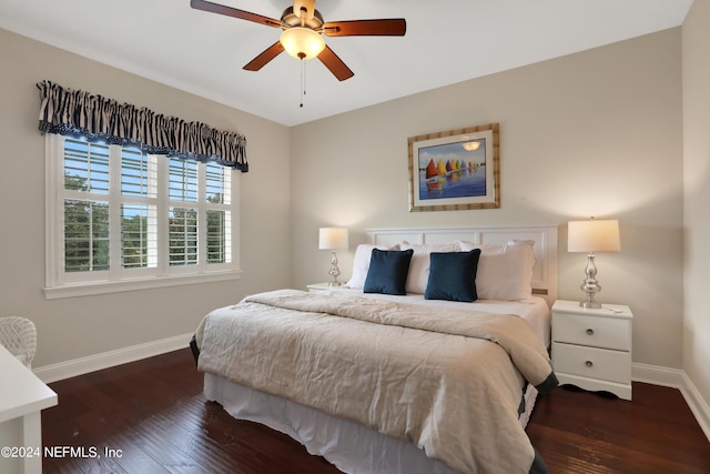 bedroom with baseboards, dark wood-type flooring, and a ceiling fan